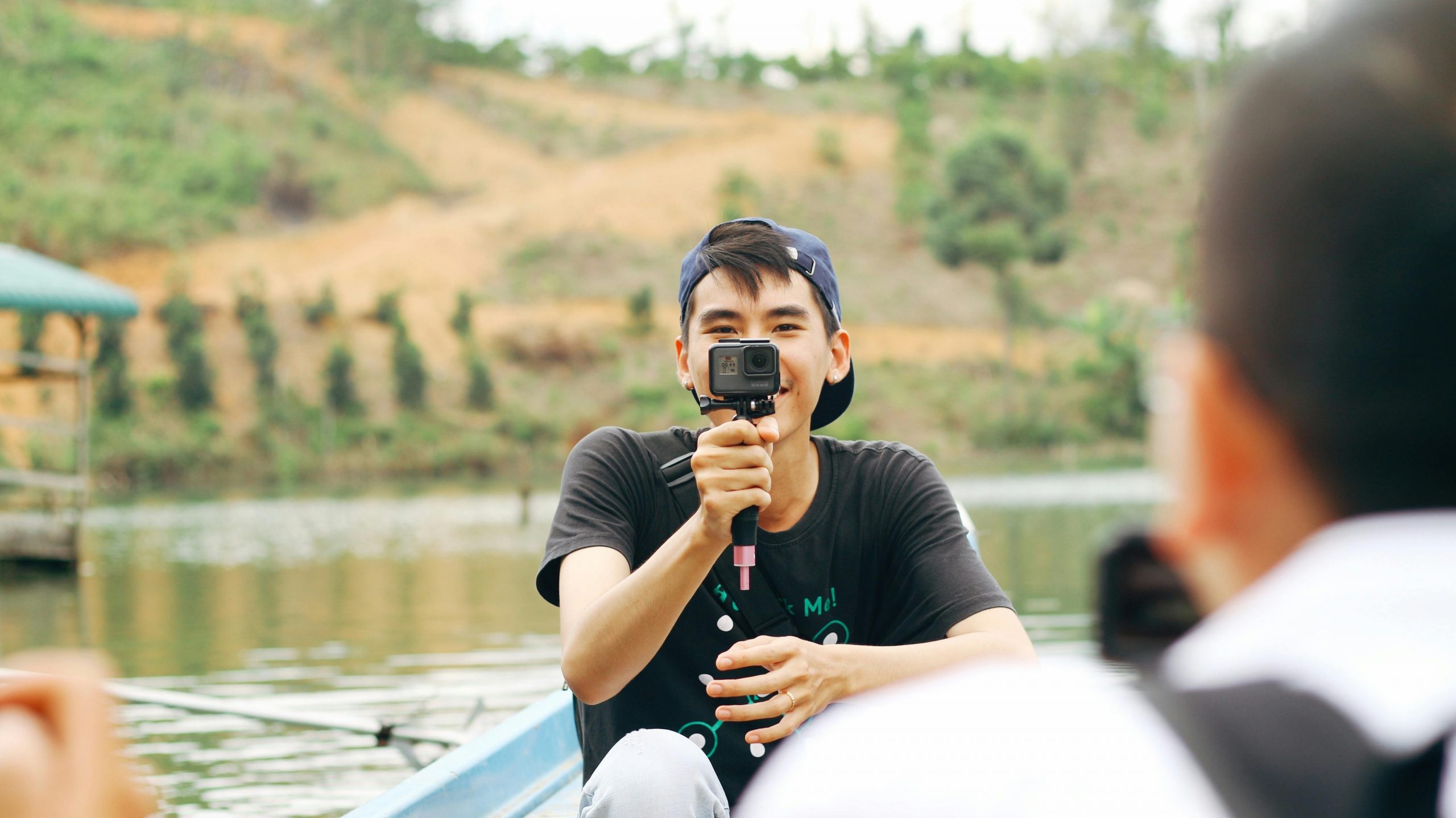 man on a boat taking a video with his gopro